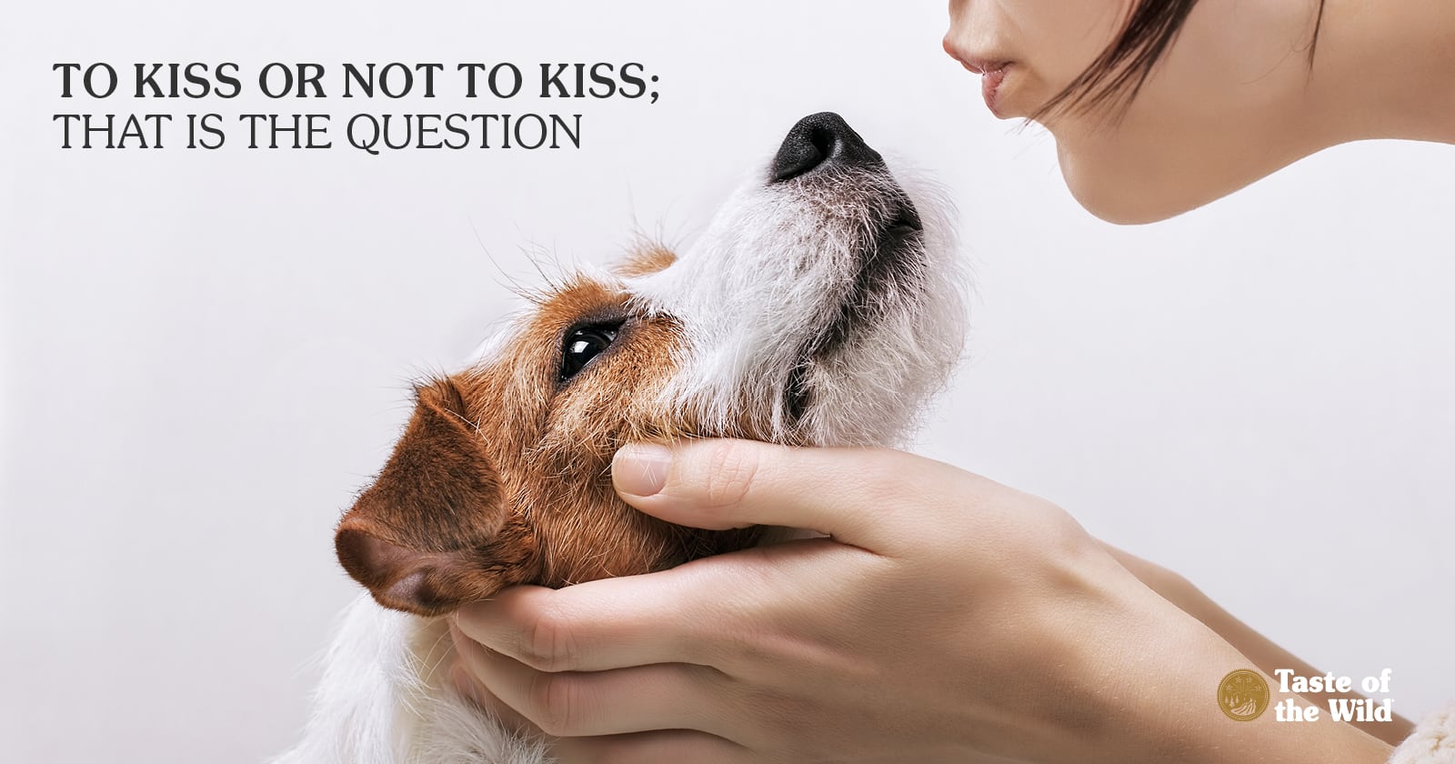 A close-up of a woman leaning in to kiss a dog on the mouth.
