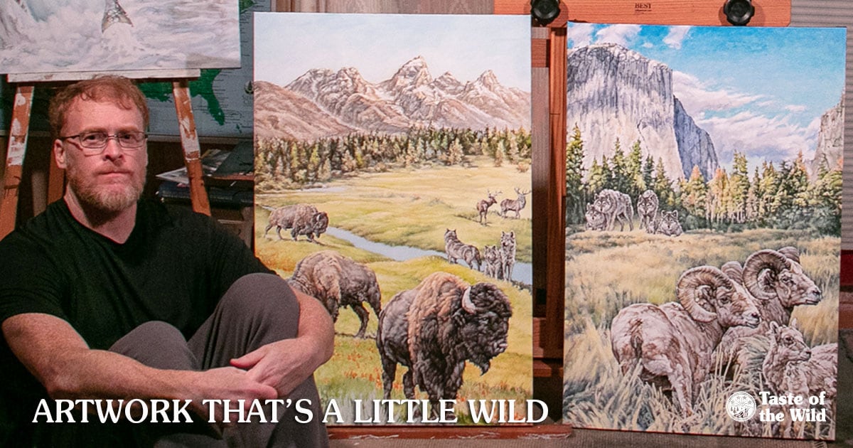 Painter Kevin Ritchie Next to Two Paintings Used on the Product Bags | Taste of the Wild Pet Food